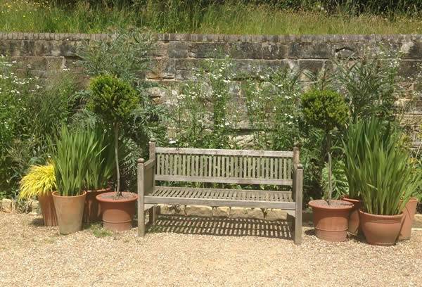 Simple yet so elegant, terracotta plots frame a garden bench