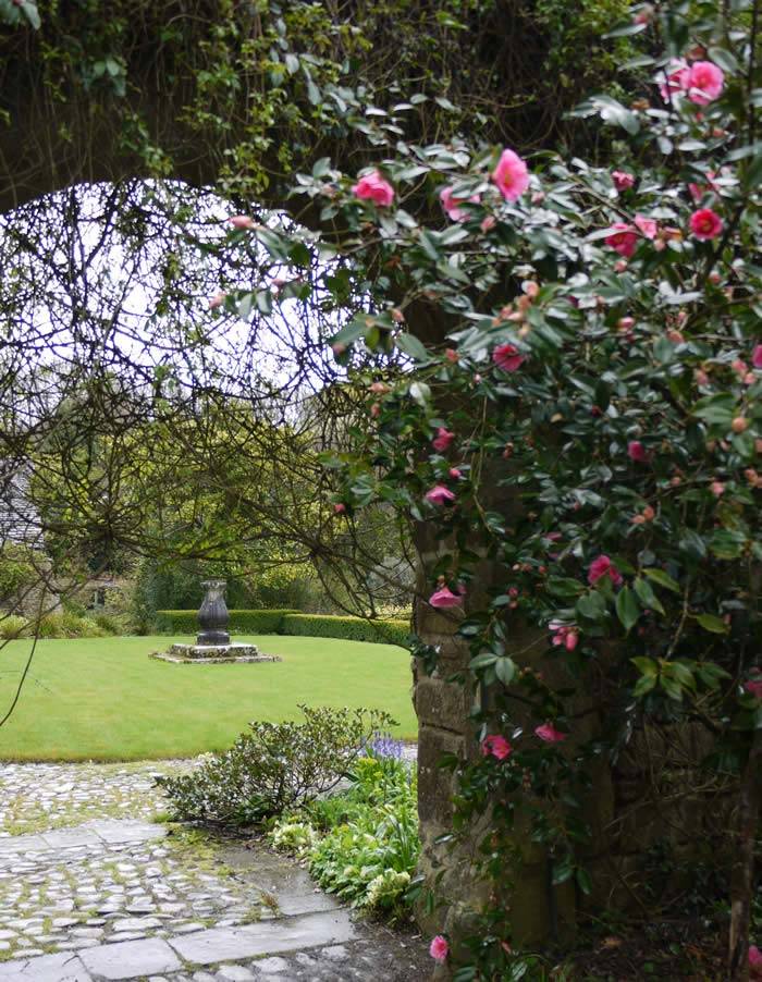 A stone archway entices the visitor through to the main house, lawns and formal gardens